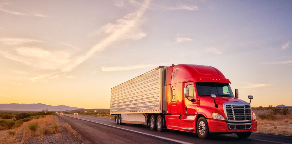 Semi and trailer driving down a highway