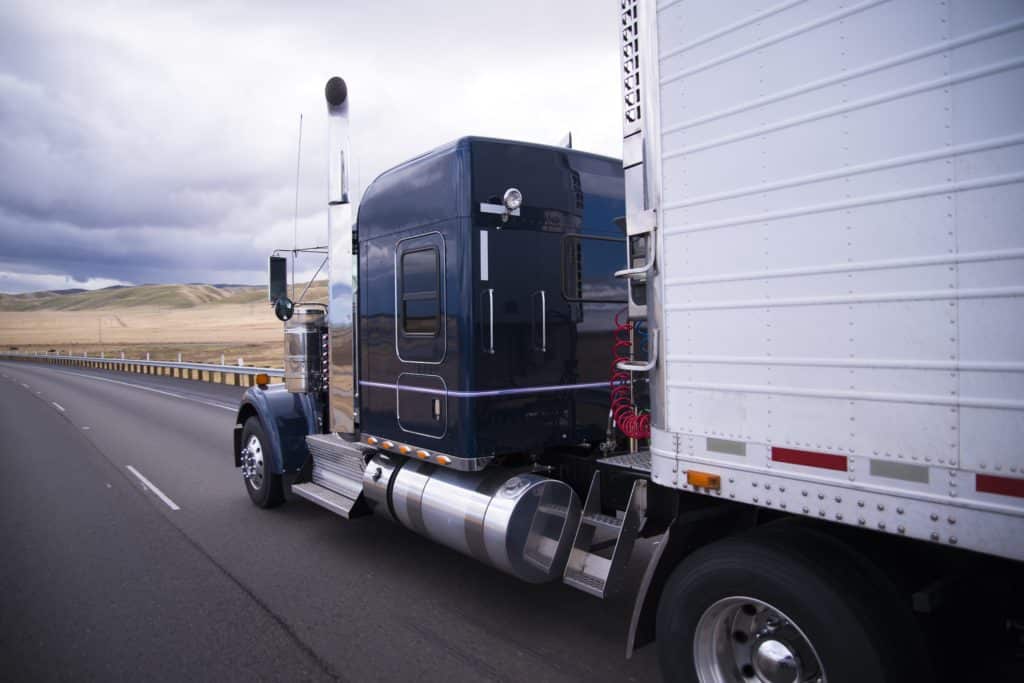 Black truck carrying freight from carrier division of Bay & Bay transportation.