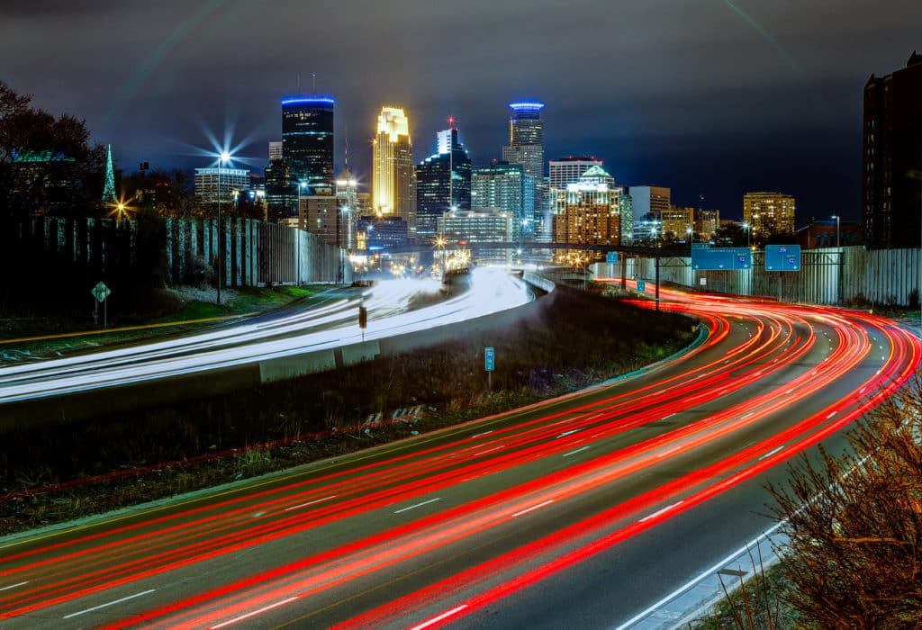 Image of the busy roads of Minneapolis Minnesota. Cars and trucks are blurry from lights.