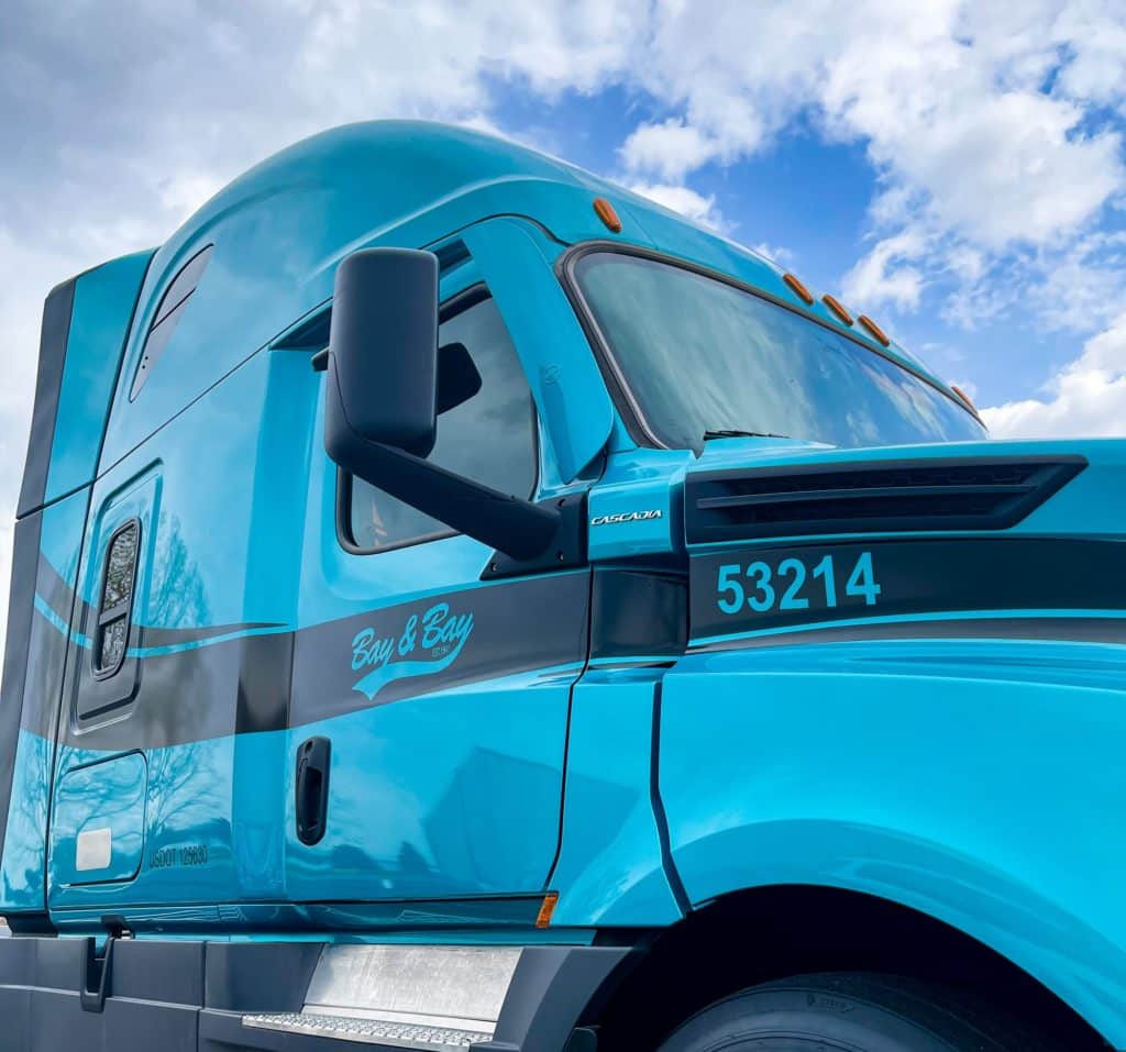 A blue truck from the full-service logistics and trucking company, Bay & Bay transportation.