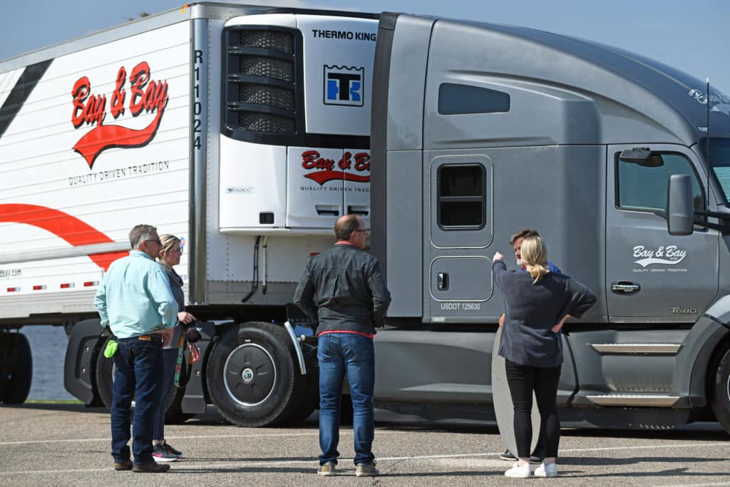 Image of people standing in front of a Bay & Bay truck and trailer.