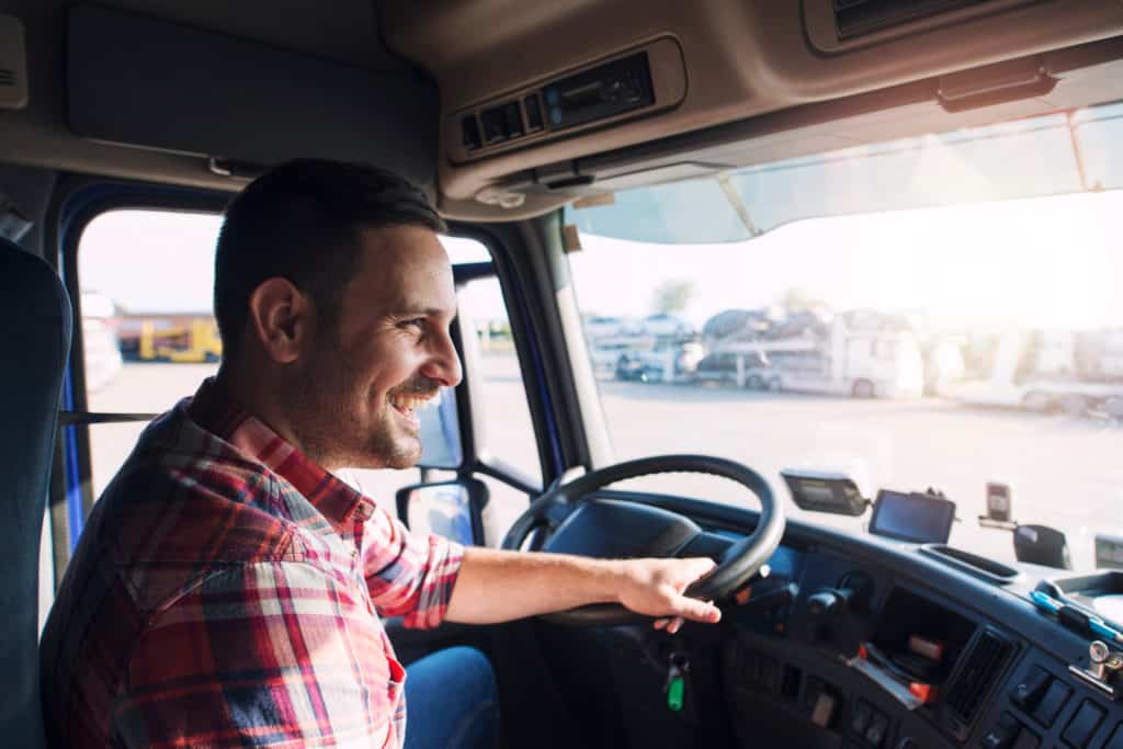 Smiling trucker on the road driving