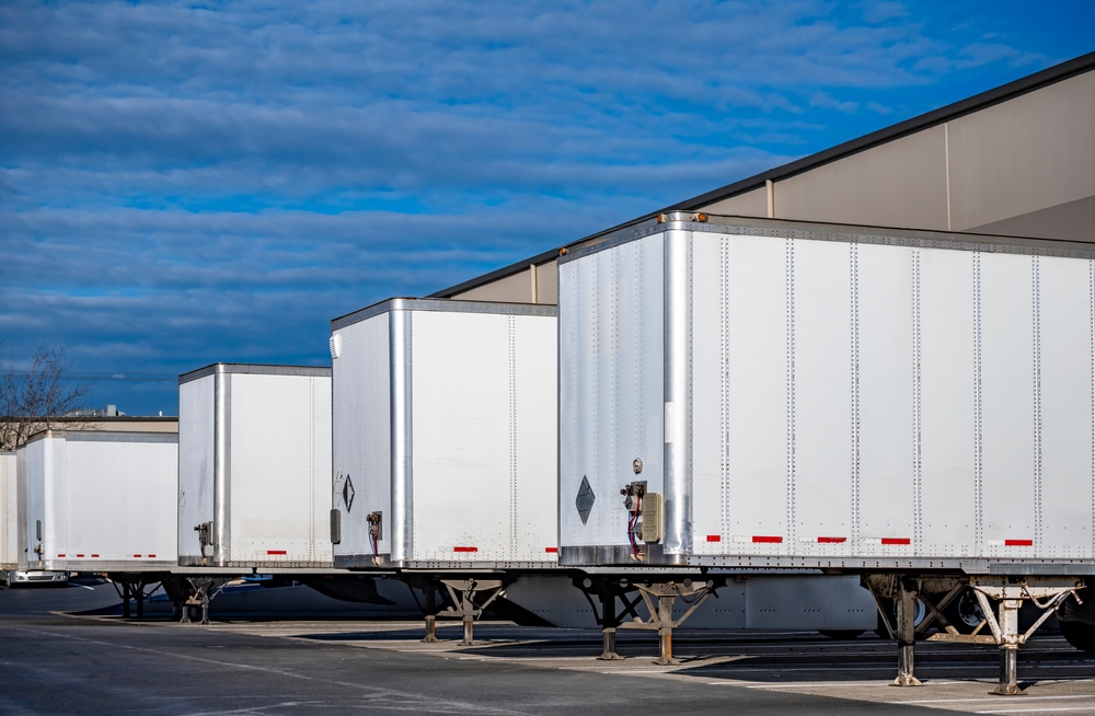 A photo of a drop-trailer pool parked at a warehouse for cross-border shipments.