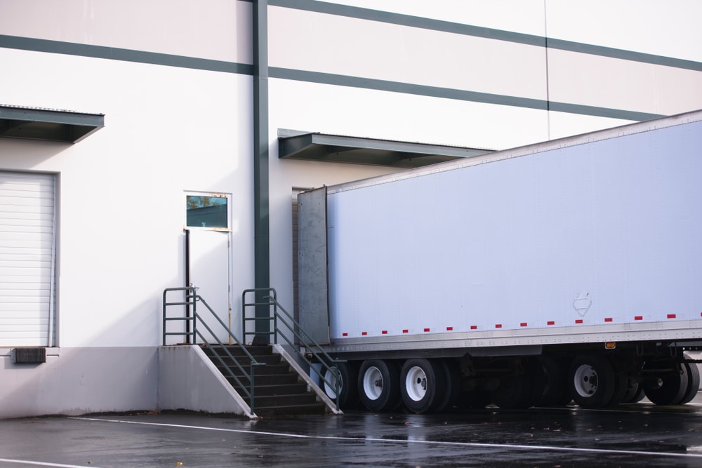 A photo of a drop-trailer parked at a warehouse for cross-border shipments.