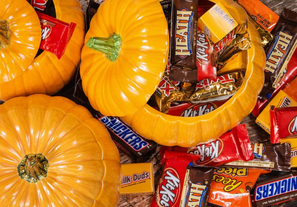A photo of a variety of candy bars inside of glass pumpkins. These shipments are prepared for Reefer Transportation for Halloween.