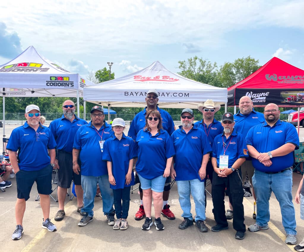 A photo of members from Bay & Bay's truck driver team and members from the office. This photo was taken at the Minnesota Truck Driving Championship representing Bay & Bay's unique driver culture.